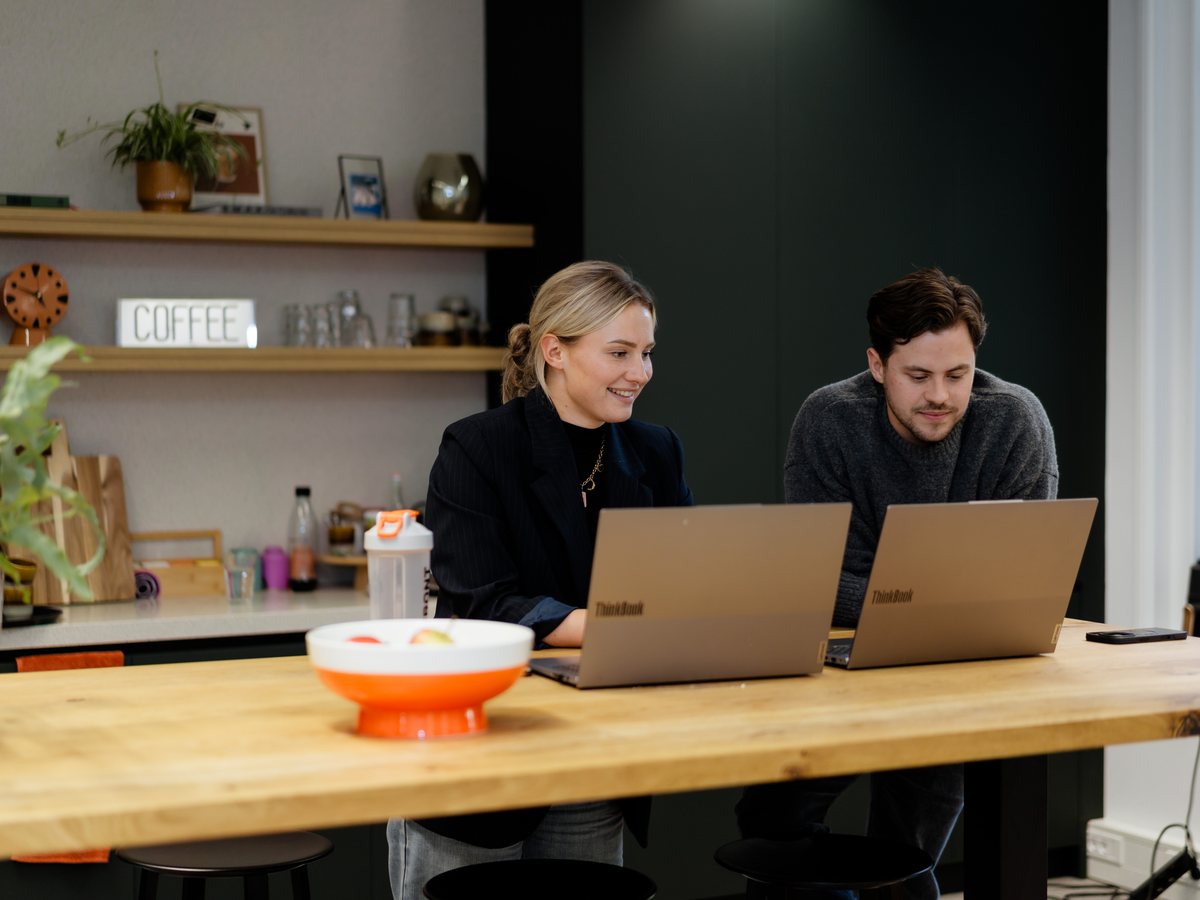 Two colleagues working together behind their laptops